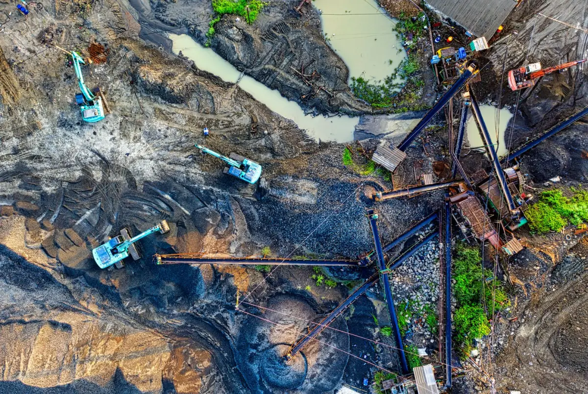 Aerial view of a quarry worksite with excavators, conveyors and material stockpiles