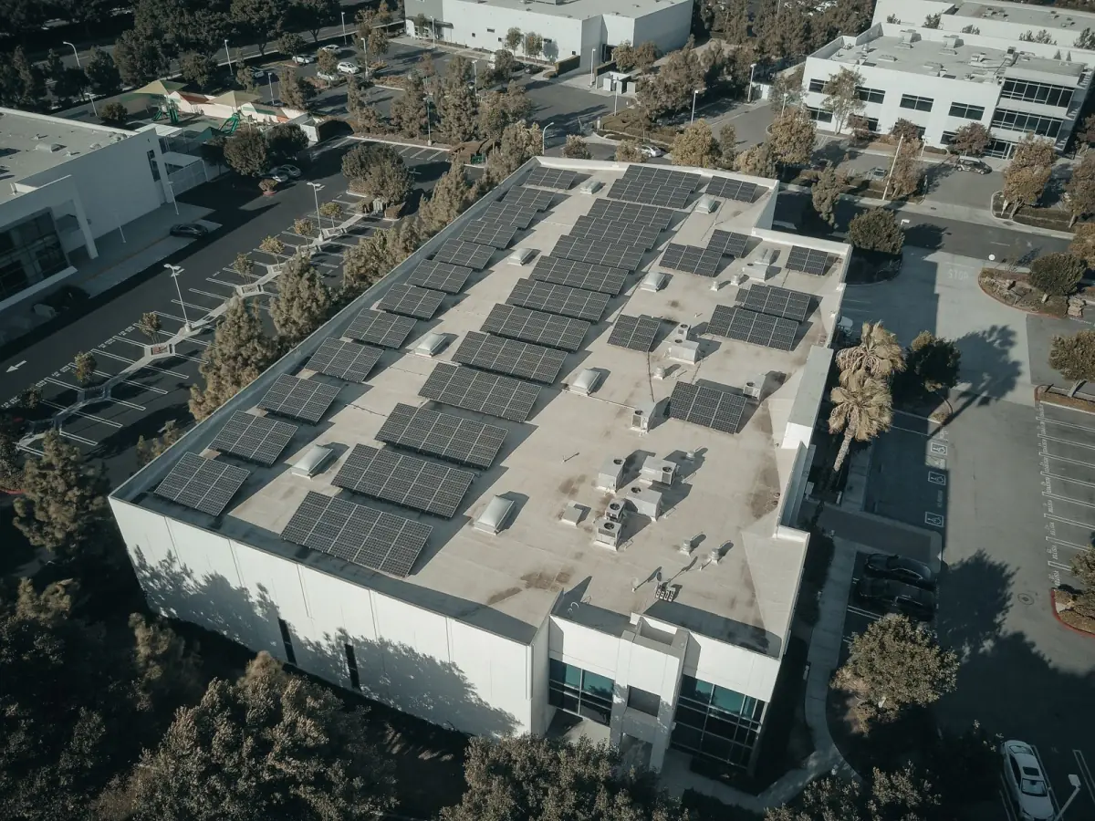 Aerial view of solar panels arranged across a commercial building roof